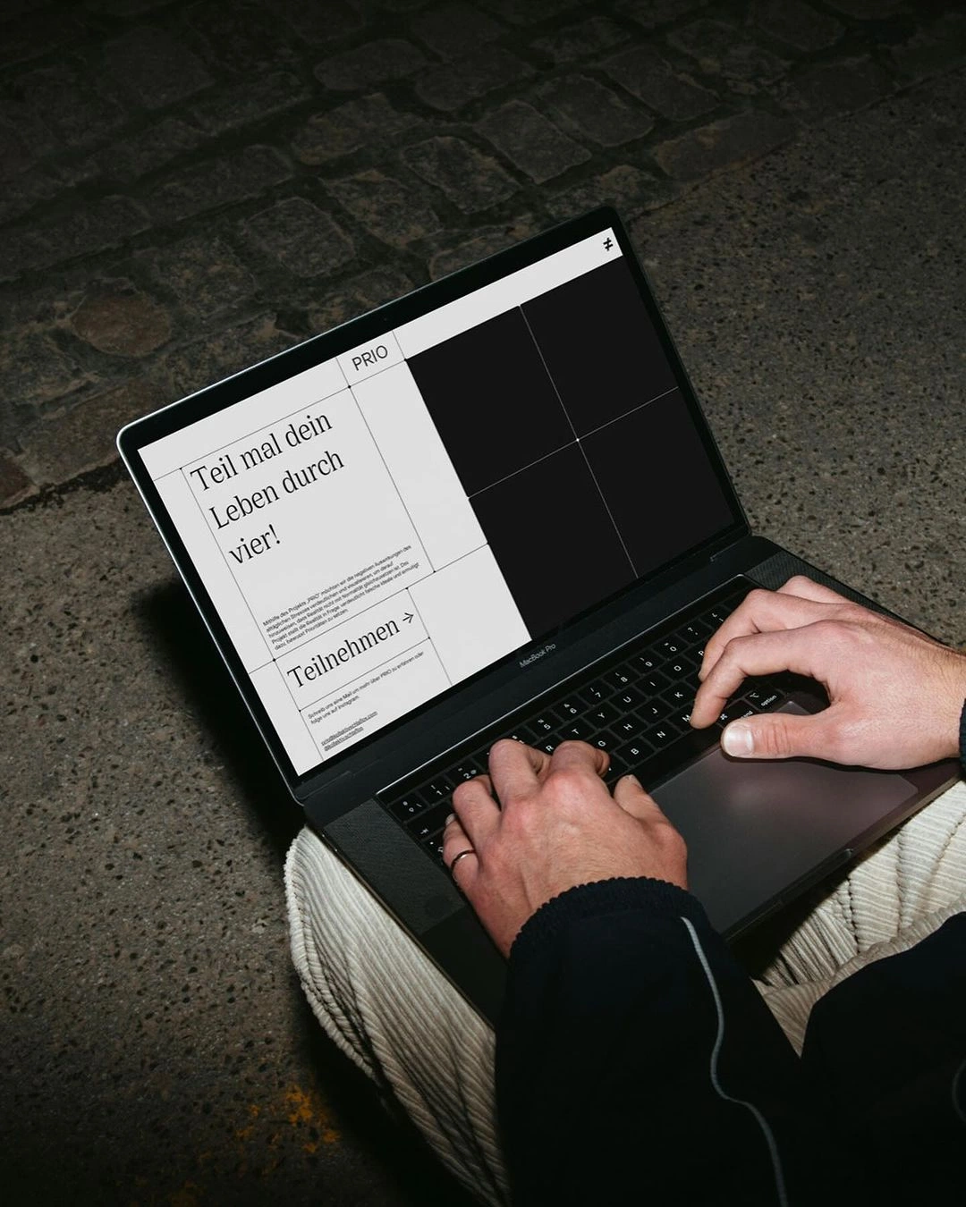 Hands typing on a laptop at night, an editorial website on screen