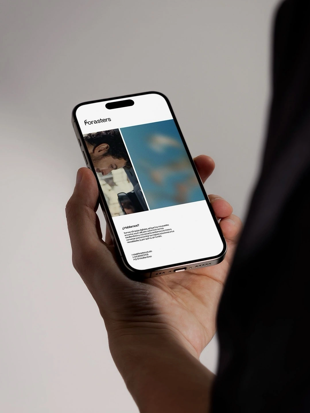 A phone in hand showing an editorial website with photography
